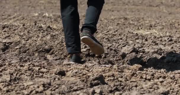 τύπος που περπατά σε παπούτσια σε ανώμαλο έδαφος - Πλάνα, βίντεο