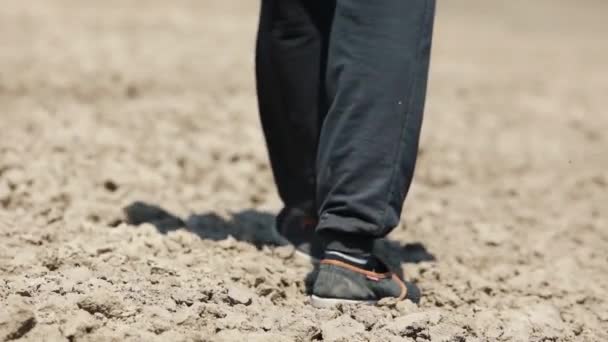 férfi séta a cipő egyenetlen talajon - Felvétel, videó