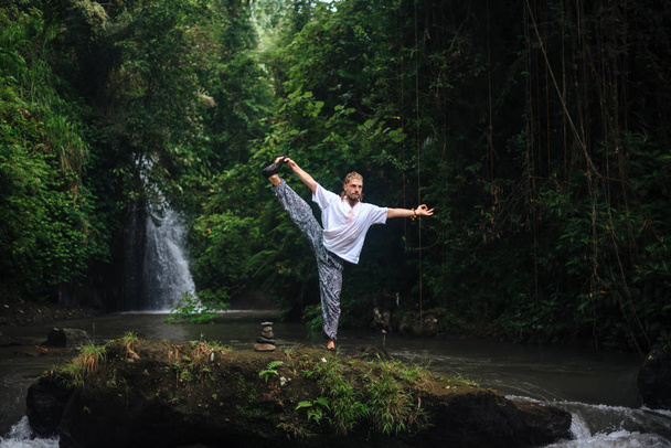 Yoga practice and meditation in nature. Man practicing near river - Photo, Image