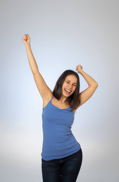 Portrait of young attractive woman celebrating success winning or feeling lucky and joyful dancing and making celebration gestures with arms isolated on blue background In People Human emotions. - Fotografie, Obrázek