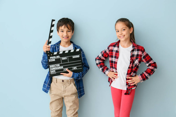 Cute little children with movie clapper on color background - Photo, Image