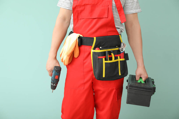 Male electrician with tools on color background - Фото, зображення