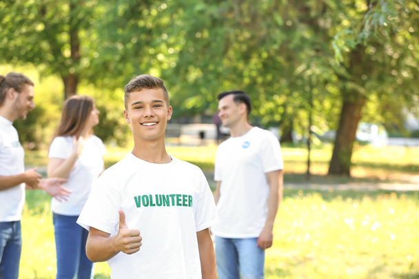 Portrait of teenage volunteer showing thumb-up outdoors - Photo, Image