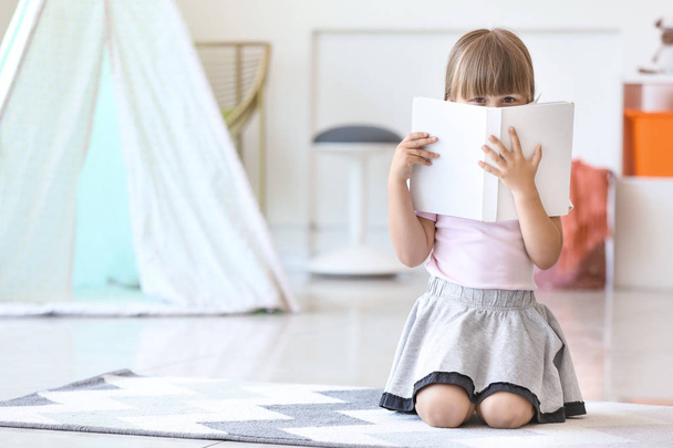 Cute little girl reading book at home - Фото, зображення