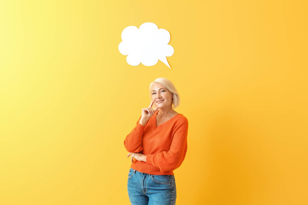 Stylish mature woman with blank speech bubble on color background - Photo, Image
