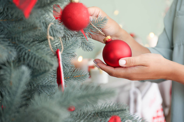 Woman decorating beautiful Christmas tree at home, closeup - Photo, Image