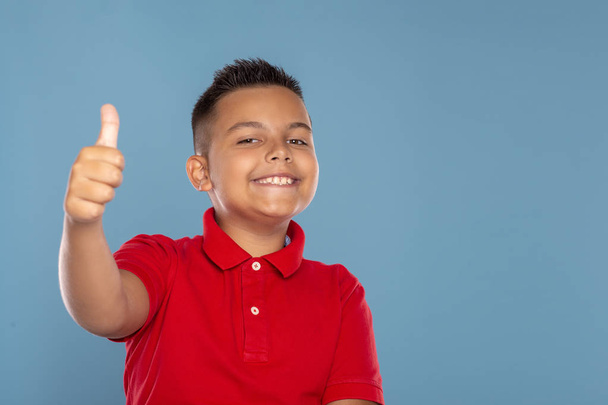 Студійний знімок молодого хлопчика, який цитує вас, що схвалює жест, ізо
 - Фото, зображення