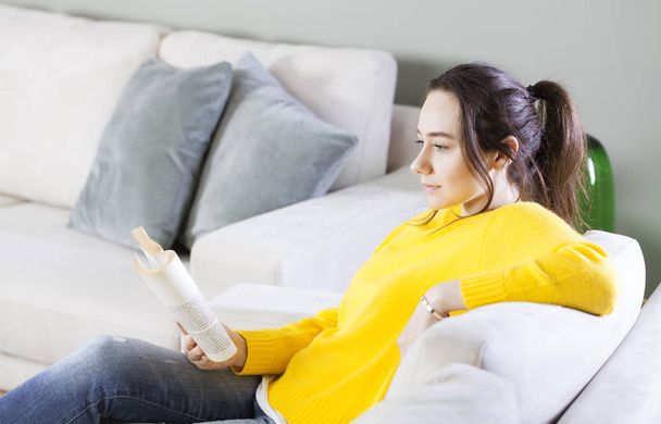 Жінка читає книгу вдома
 - Фото, зображення