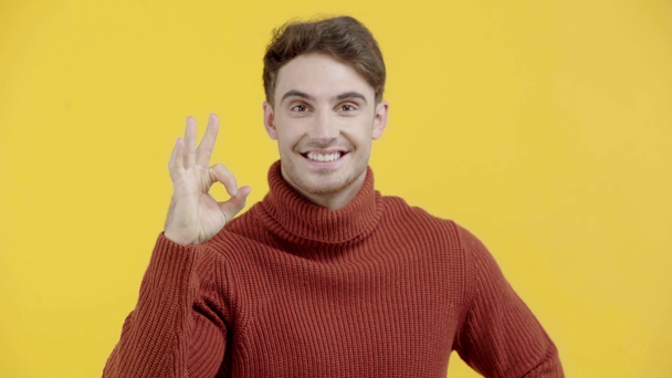 happy man in sweater showing ok sign isolated on yellow - Footage, Video