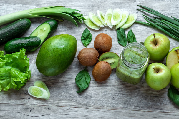 Fresh green food on a light table. Avocados cucumbers cabbage apples beans kiwi onions broccoli. The concept of healthy food, detox vegetarianism. Copy space flat lay. - Foto, imagen