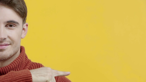 cropped view of man in sweater pointing with finger isolated on yellow - Filmagem, Vídeo