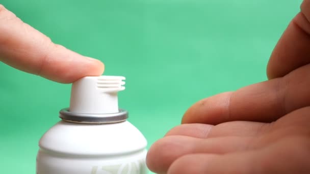 Menselijke handen knijpen scheerschuim voor het scheren van een fles cosmetische. Op een groene achtergrond. Slow Motion. - Video