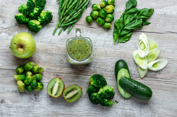 Fresh green food on a light table. Avocados cucumbers cabbage apples beans kiwi onions broccoli. The concept of healthy food, detox vegetarianism. Copy space flat lay. - Fotografie, Obrázek