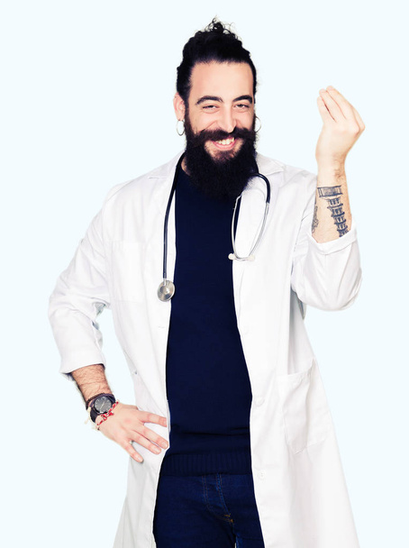 Doktor uzun saçlı tıbbi ceket ve kendine güvenen ifade el ve parmak ile İtalyan jest yapıyor stetoskop - Fotoğraf, Görsel
