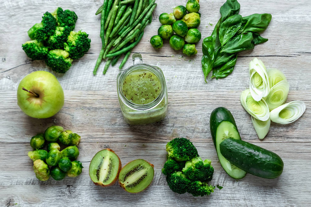 Fresh green food on a light table. Avocados cucumbers cabbage apples beans kiwi onions broccoli. The concept of healthy food, detox vegetarianism. Copy space flat lay. - 写真・画像