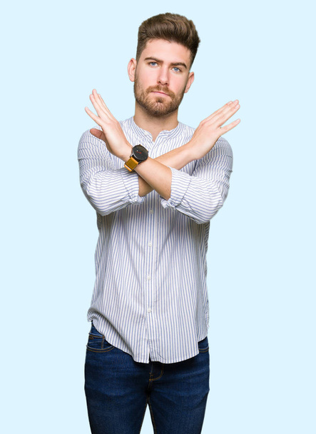 Jeune bel homme Expression de rejet croisant les bras faisant signe négatif, visage en colère
 - Photo, image