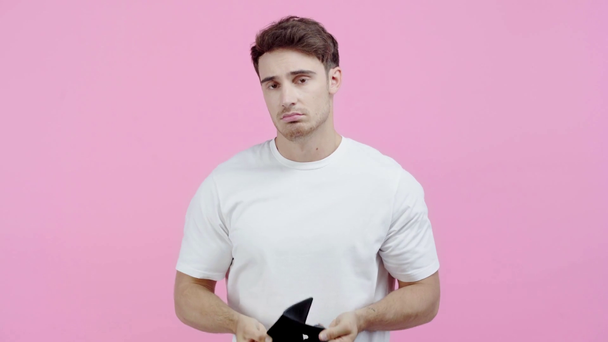 pobre hombre sacudiendo cartera vacía aislado en rosa
 - Metraje, vídeo