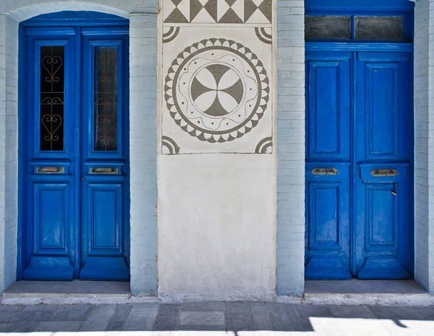 House facade, with two blue colored doors and traditional black and white geometrical shapes at Pyrgi village, Chios island, Greece. - Photo, Image