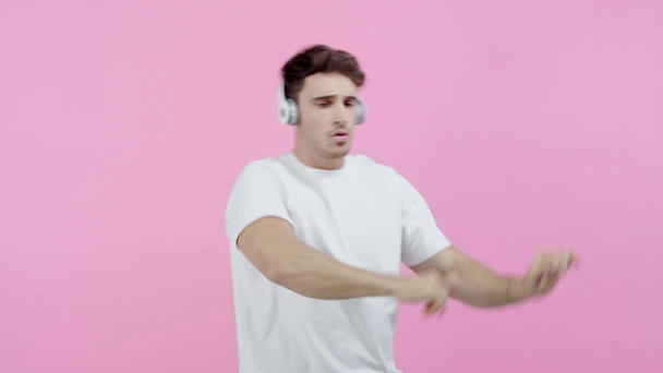 podekscytowany Mężczyzna tańczy w słuchawkach na białym tle - Materiał filmowy, wideo