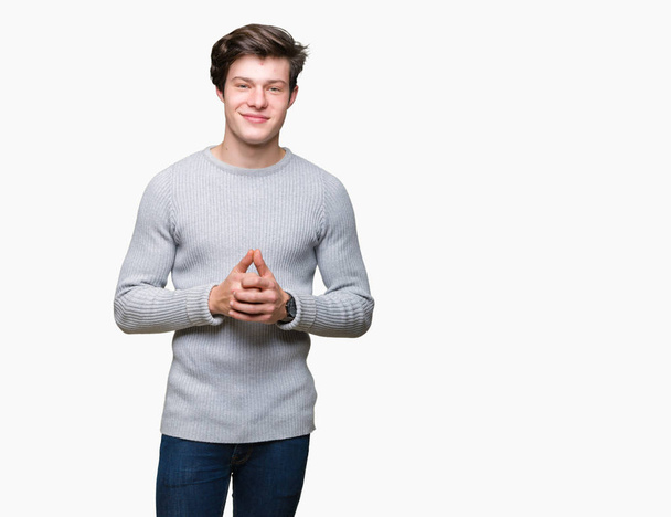 Jonge knappe man winter trui dragen over geïsoleerd samen achtergrond handen en vingers gekruist glimlachen, ontspannen en vrolijk. Succes en optimistisch - Foto, afbeelding