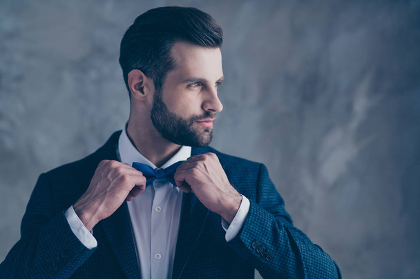 Profile side of minded man touching his blue bow tie looking wearing blazer jacket isolated over grey background - Foto, Bild