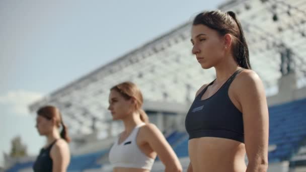 陸上競技で女性ランナーは、レースの前にスターティング ブロックでしゃがみを追跡します。スローモーションで - 映像、動画
