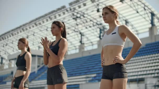 Oldalnézetből egy csoport női sportoló kezdődő ő Sprint egy futó pályán. Runner vesz le a kiindulási blokkok futópálya - Felvétel, videó