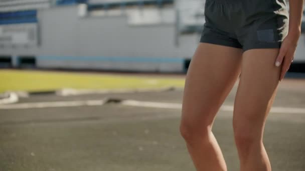 Die schlanke junge Athletin ist in der Lage, in Zeitlupe in die Pads auf der Bahn zu laufen. - Filmmaterial, Video