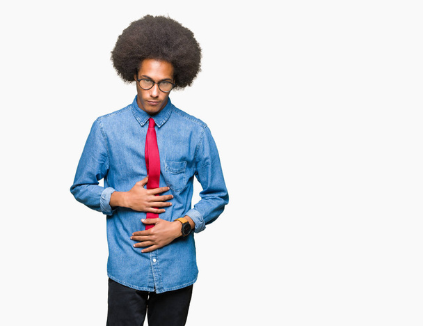 Young african american business man with afro hair wearing glasses and red tie with hand on stomach because nausea, painful disease feeling unwell. Ache concept. - Photo, Image