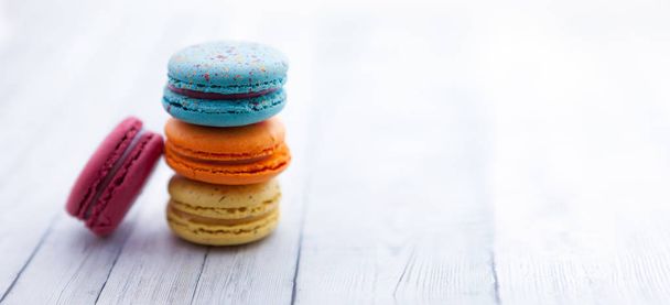 French crash macarons. Stack of colorful macaroon on wooden table, space for text - Zdjęcie, obraz