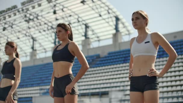 Corredores do sexo feminino no atletismo rastreiam agachamento nos blocos iniciais antes de uma corrida. Em câmara lenta
 - Filmagem, Vídeo