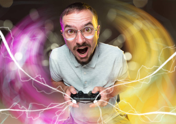 Enthusiastic gamer. Joyful young man holding a video game controller - Photo, Image