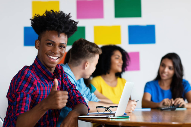 Laughing african american male student at computer with group of - Foto, Imagem