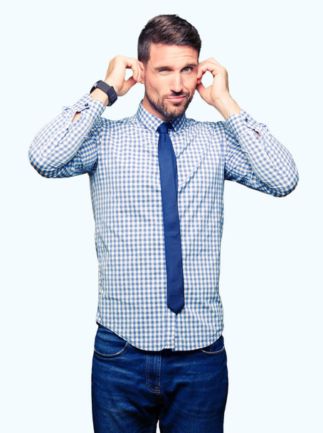 Pohledný podnikatel kravatu pokrývající uši prsty s otrávený výraz pro hluk z hlasité hudby. Neslyšící koncepce. - Fotografie, Obrázek