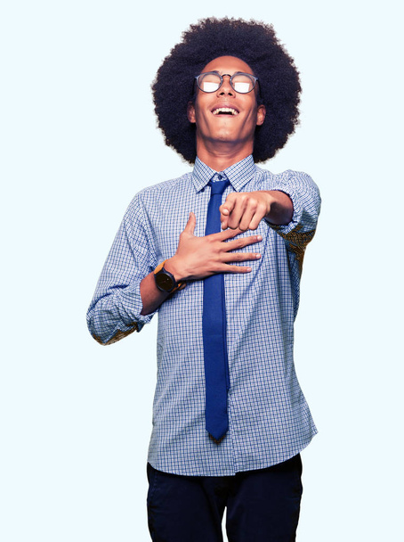 Jeune homme d'affaires afro-américain avec des cheveux afro portant des lunettes Rire de vous, pointant vers la caméra avec la main du doigt sur la poitrine, expression de honte
 - Photo, image