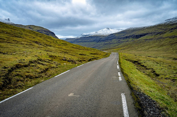 Dramatic landscape of Faroe Islands with remote road in a middle of mountains. - Фото, изображение