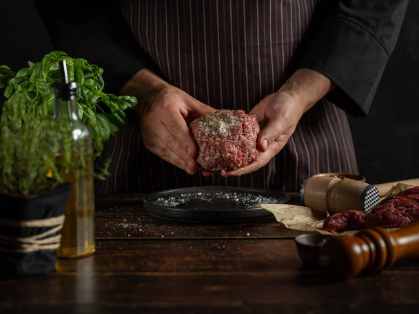 Chef preparing minced meat with spices and herbs - 写真・画像
