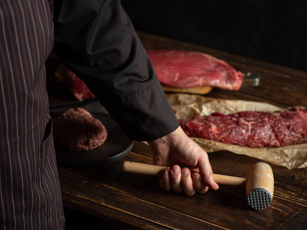 man preparing raw meat  - Foto, afbeelding