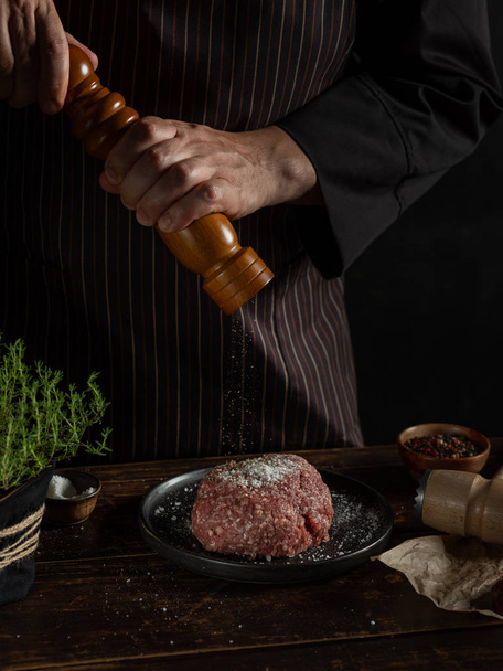 Chef preparing minced meat with spices and herbs - Foto, Bild