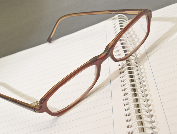 Caderno e óculos
 - Foto, Imagem