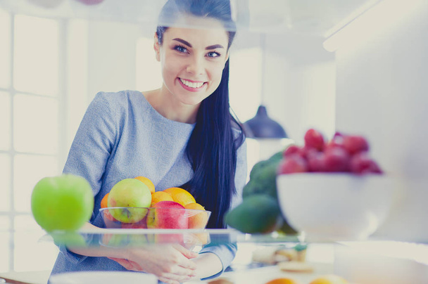 Usmívající se žena vytahuje čerstvé ovoce z ledničky, zdravý stravovací koncept - Fotografie, Obrázek