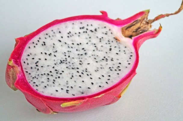 Dragon hedelmiä tai pitaya vaaleanpunainen kuori ja mehukas valkoinen massa mustia siemeniä kevyellä taustalla
 - Valokuva, kuva