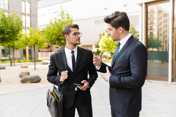 Two attractive young businessmen wearing suits - Foto, Imagem