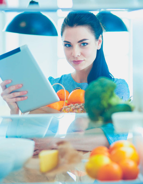 Smiling woman taking a fresh fruit out of the fridge, healthy food concept - Foto, afbeelding