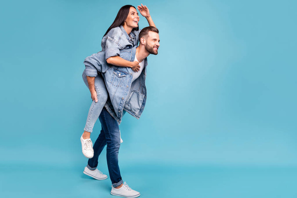 Full size profile side photo of cheerful people staring wearing denim jeans jackets isolated over blue background - Foto, Imagen
