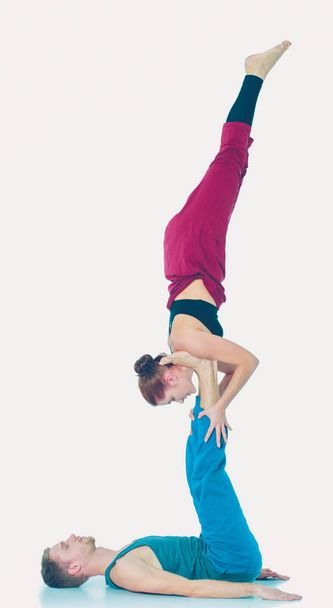 Young athletic couple practicing acroyoga. Balancing in pair. - Φωτογραφία, εικόνα