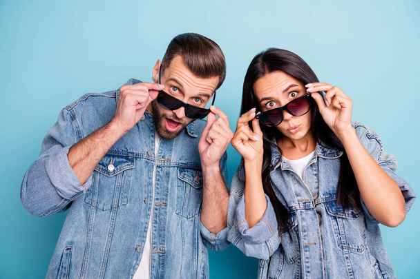Close up photo of impressed people touching their specs looking wearing denim jeans jackets isolated over blue background - Foto, afbeelding