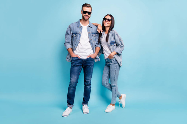 Full length photo of charming spouses looking with beaming smile wearing denim jeans eyeglasses eyewear isolated over blue background - Valokuva, kuva