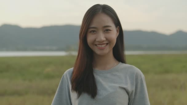 Portret pięknej młodej Azjatki uśmiechniętej patrzeć na aparat ciesząc się zabawą razem latem podróży. Azjatycki styl życia przyjaciół podróżuje wakacje. - Materiał filmowy, wideo