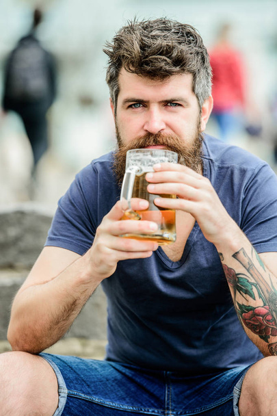 Guy having rest with cold draught beer. Hipster relaxed drinking beer outdoor. Light ales or dark stouts drink them all. Man with beard and mustache hold beer glass outdoors. Cafe summer terrace - Zdjęcie, obraz